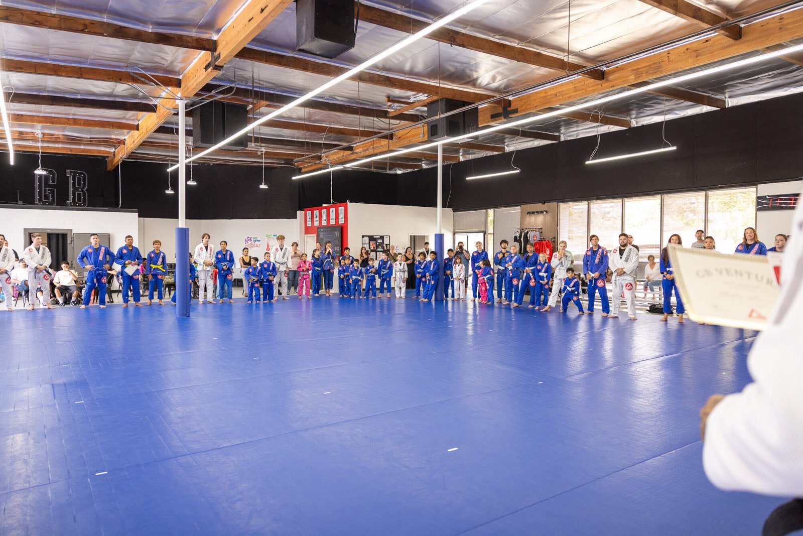 Kids and teens lined up on the mats at a Gracie Barra Ventura belt ceremony