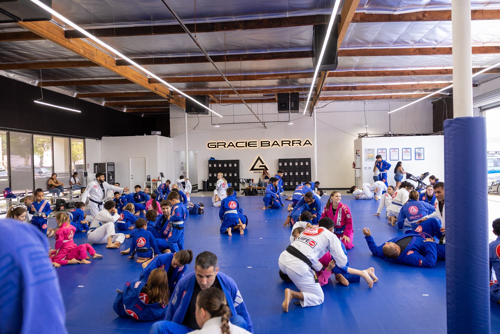 The Gracie Barra Ventura training room full of kids and adults drilling on the blue mats